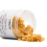 Golden-yellow Berry White THCA crumble wax spilling from a clear jar, ideal for hemp flower products