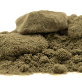 A mound of earthy greenish-brown banana og thca kief with concentrated potency and legendary genetics rock embedded