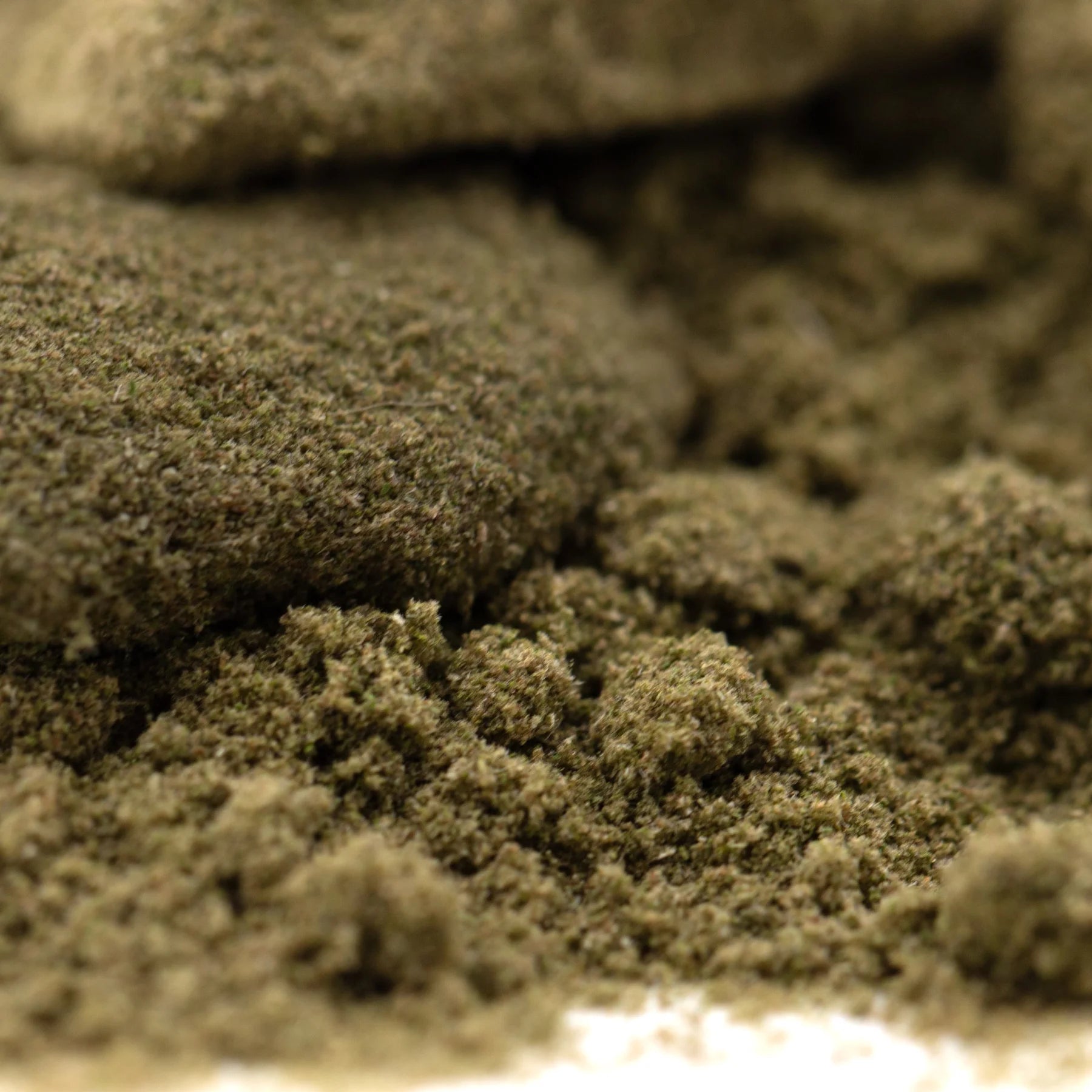 A mound of finely ground green thca kief with a tropical character from legendary banana og full-term wholesale