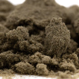 A mound of coarse dark brown banjerine thca kief with a textured surface showcasing paradoxical citrus wholesale positioning