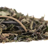 Dried green tea leaves with curled edges and fine hairs in blue sugars greenhouse thca trim for sugar cookies