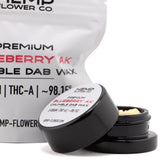 Black cylindrical container with white label holding light-colored blueberry ak thca crumble wax with kush-like flavor