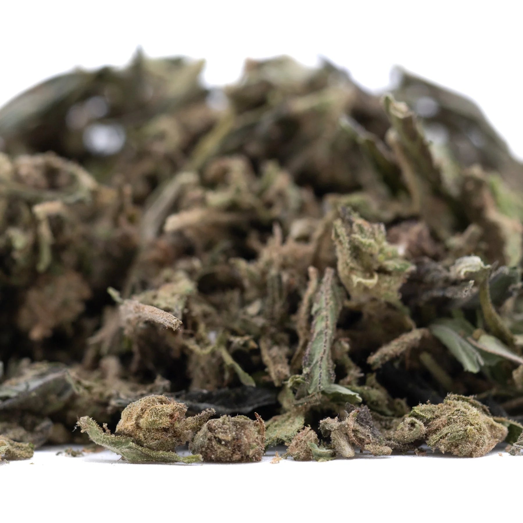 A pile of dried blueberry muffin thca trim hemp flower buds with green and brown hues for wholesale use