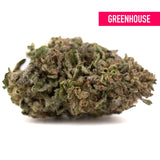 A dense bolor tartz greenhouse thca hemp flower bud with green and brown hues covered in fine trichomes