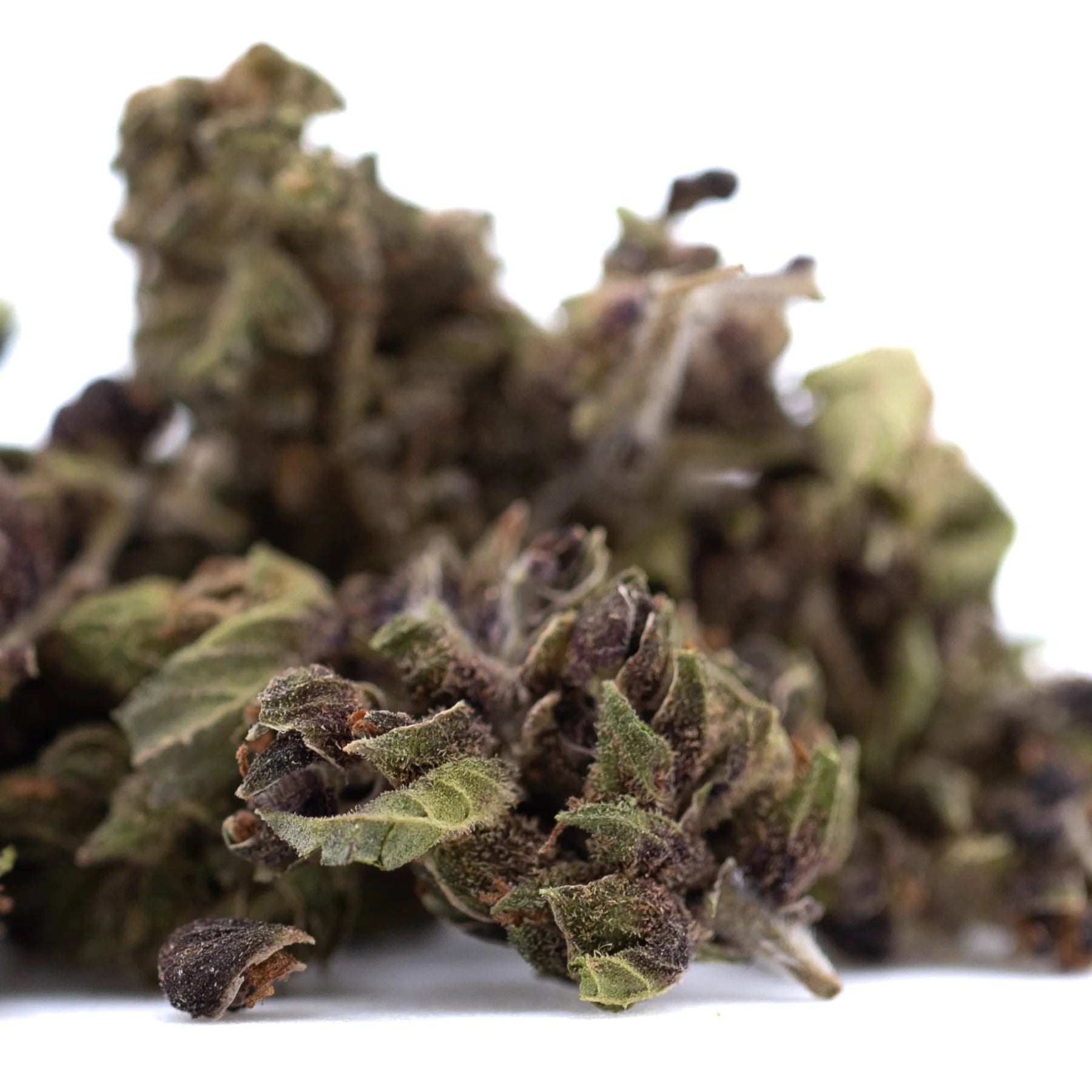 Dense dried bubba kush cbd smalls hemp flower with green and purplish hues and intricate leafy textures for afghani indica fans