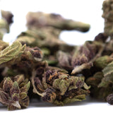 Dried bubba kush cbd smalls hemp flower with green and purple hues covered in dense trichomes afghani indica quality
