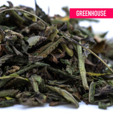 A pile of dried green thca trim leaves with dark and light shades featuring some stems for cali burger triple-cross genetics