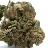 Candy pave’s greenhouse smalls hemp flower dense green bud with trichomes and orange pistils close-up view