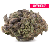 A dense resinous chicken and waffles thca hemp flower with green and purple hues covered in trichomes from a greenhouse
