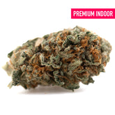 A dense resinous crater lake og indoor thca flower bud with green orange hues and white trichomes like oregon huckleberry