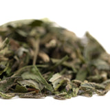 A pile of dried greenish-brown greenhouse thca trim with visible stems and textured surfaces for hemp flower northern lights
