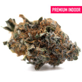 A dense resinous dea-4 indoor thca flower bud with green and orange hues covered in trichomes for indoor cultivation total cannabinoid and black domina quality