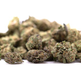 A pile of dried dea-4 thca greenhouse smalls cannabis buds with green brown and purple hues like northern lights hemp flower