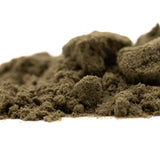 A mound of dark olive-green durban poison thca kief with granular texture showcasing landrace genetics and legendary ed rosenthal quality