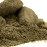 A mound of coarse dark green thca kief full-term from dark heart nursery with a textured sour lemon-lime surface