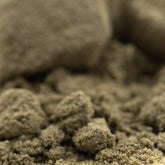 A coarse earthy-brown face fat THCa kief pile with gritty texture highlighting hemp flower and all-day versatility use