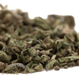 A pile of dried greenish-brown foot full-term thca cannabis buds with trichomes and leafy textures for mental clarity