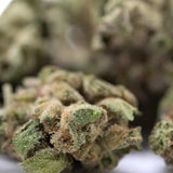 Blue Dream THCa flower smalls: marijuana bud with green leaves and white trichomes