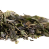 Dried mint leaves in green and dark purple hues with stems and curled edges in gas monkey greenhouse thca trim hemp flower