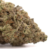 Dense textured greenhouse thca gas thca flower with kush genetics in green and brown hues and substantial potency trichomes