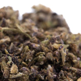Dense textured glue full-term cbd trim hemp flower trim with green and brown hues covered in fine trichomes