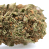 A dense humboldt dream thca flower with green and amber resinous buds covered in fine trichomes