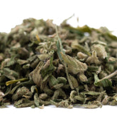 A pile of dried greenish-brown jelly donut full-term thca trim with trichomes and stems for deeply relaxing use
