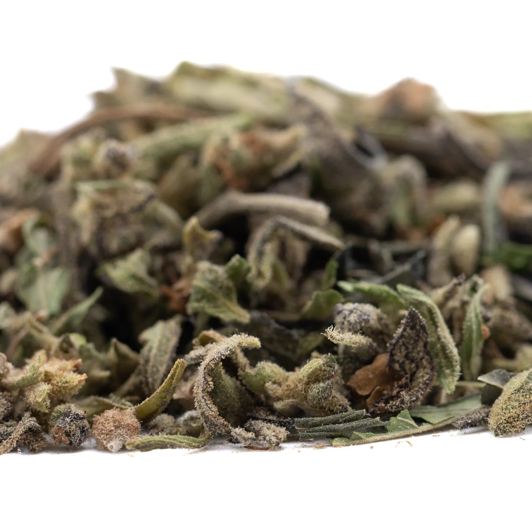 Dried mendo breath thca trim with green and brown herbal leaves and a textured fuzzy surface for vanilla caramel candy