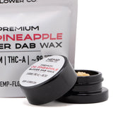 Black cylindrical container with white label holding light-colored crumbly thca budder wax from pineapple og hemp flower