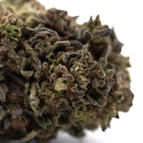 A dense orange runtz thca flower bud with green and purple hues covered in trichomes for morning motivation