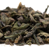 Dried green tea leaves with curled texture in party animals indoor thca trim wholesale featuring animal cookies hints