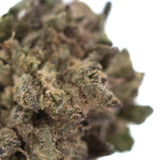 A dense textured hemp flower bud with green and brown hues in poppin bottlez thca greenhouse smalls rozay cake