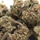 A dense royal highness hemp flower bud with green and brown hues covered in fine lab tested trichomes