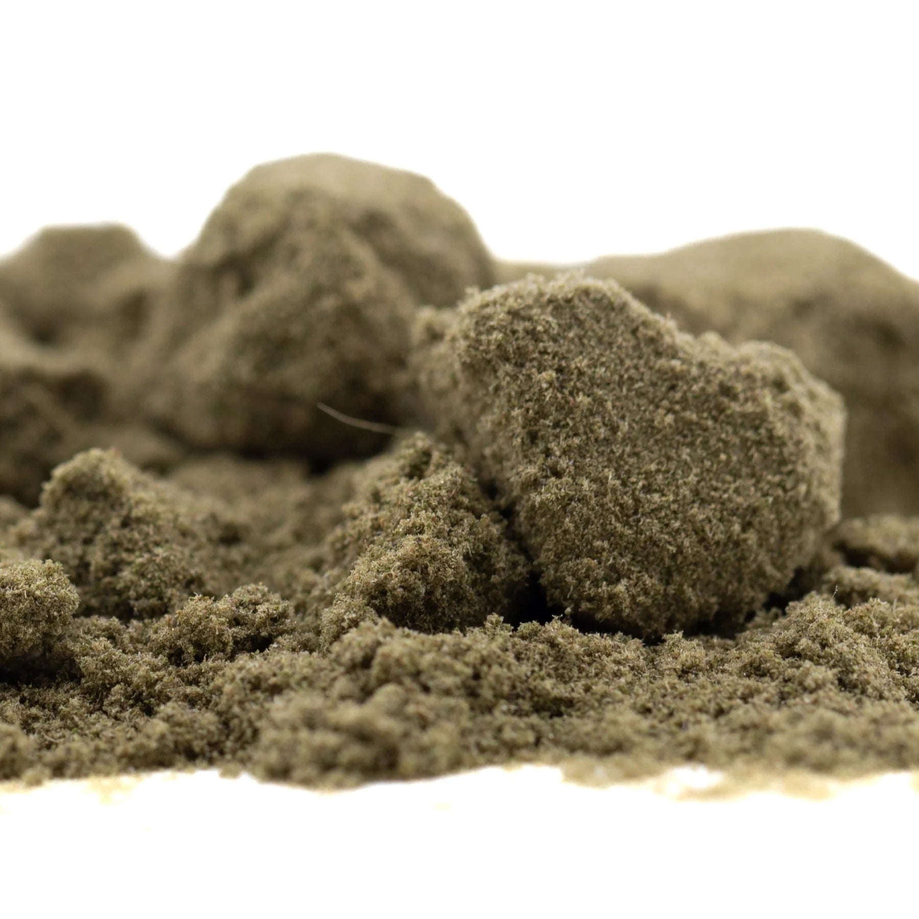 A mound of fine olive-green thca kief from legendary sour diesel hemp flower in sour apple full-term blend