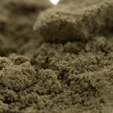 A close-up of coarse greenish-brown sour diesel thca kief with gritty texture for legendary fuel mexican sativa use