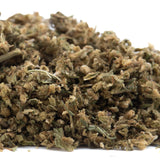 A pile of sour hawaiian haze cbd trim herb with green and brown hues featuring trichomes and leafy textures