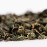 Dried cannabis flower buds and leaves from Sour Runtz Indoor Thca Trim with rich terpene profile