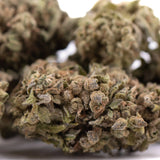Dense resinous strawberry cheesecake thca flower with green and brown hues covered in fine trichomes wholesale thca flower