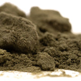 A mound of coarse dark greenish-brown powder with granular texture of strawberry cheesecake thca kief full-term dessert flavor