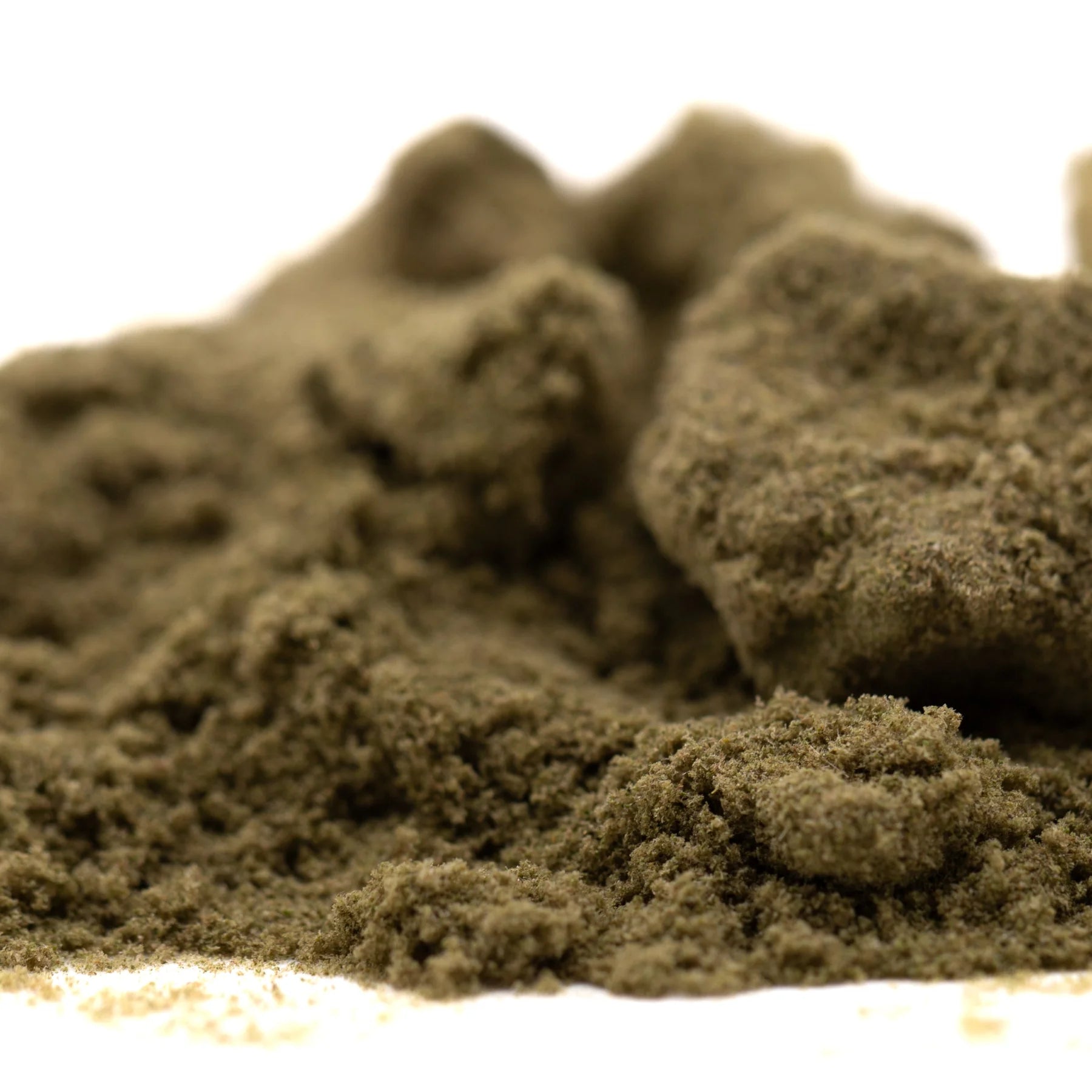 A mound of coarse earthy brown powder of strawberry cheesecake thca kief full-term with dessert flavor granules
