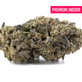 A dense street guru indoor thca hemp flower bud with green and purple hues covered in fine trichomes