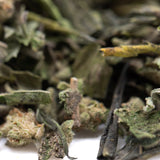 Dried subzero greenhouse thca trim buds with frosty trichomes and green leaves for chronic pain therapeutic effects