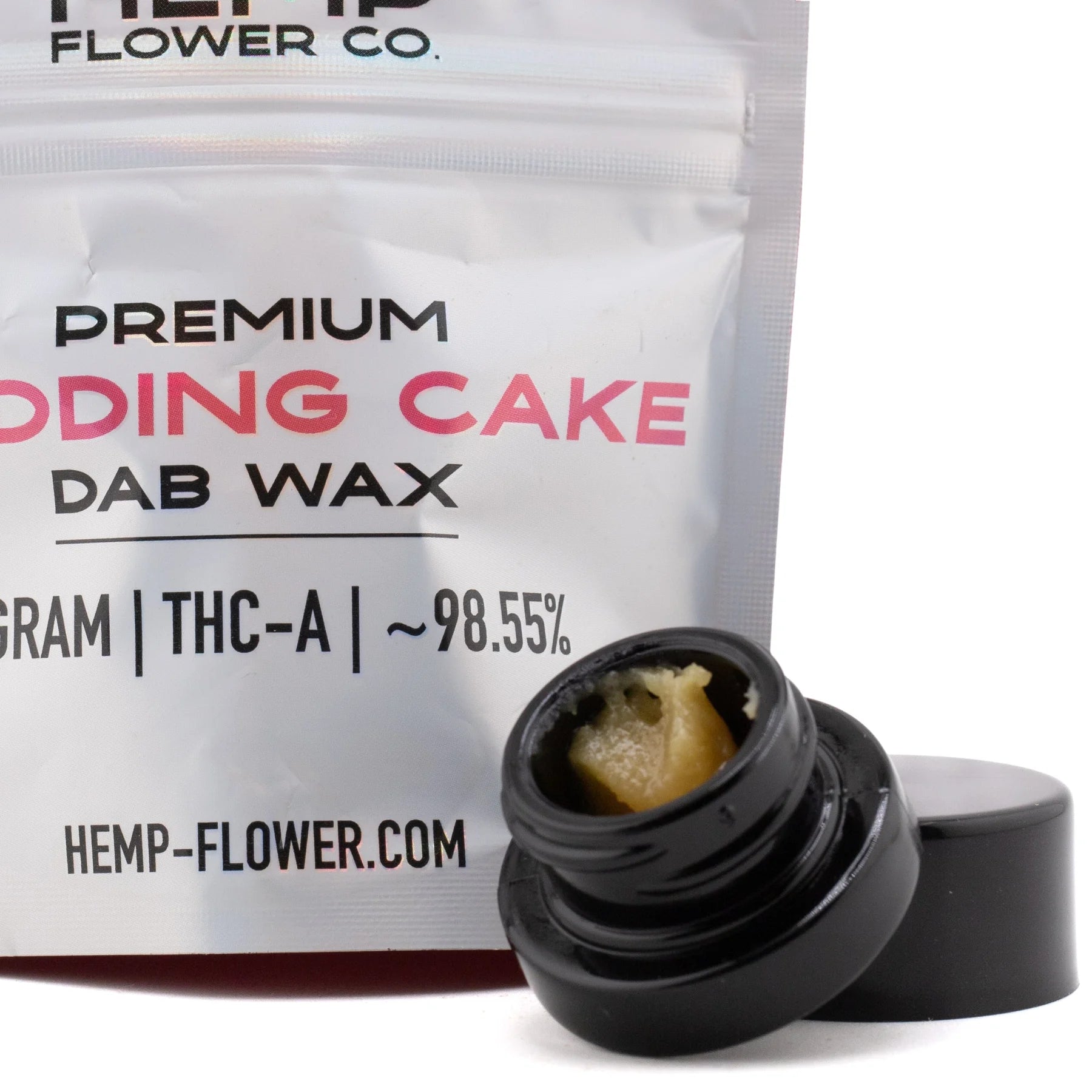 Black glass jar of golden-yellow wedding cake thca dab wax 1g with open lid beside it for concentrate use