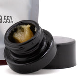 Black plastic jar of yellowish textured thca dab wax wedding cake 9855 containing triangle kush extract 1g