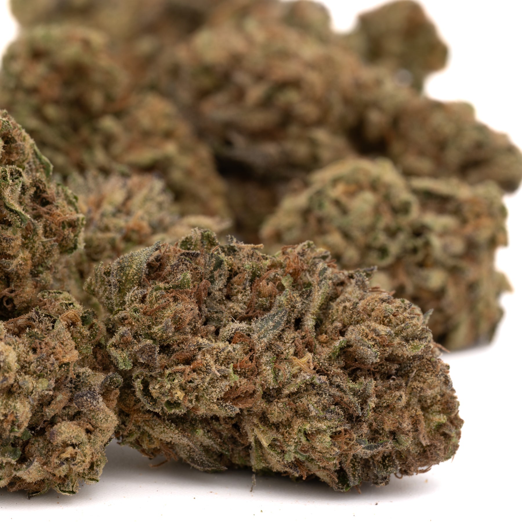 Dried peanut butter THCa hemp flower with green, brown, orange hues and trichomes