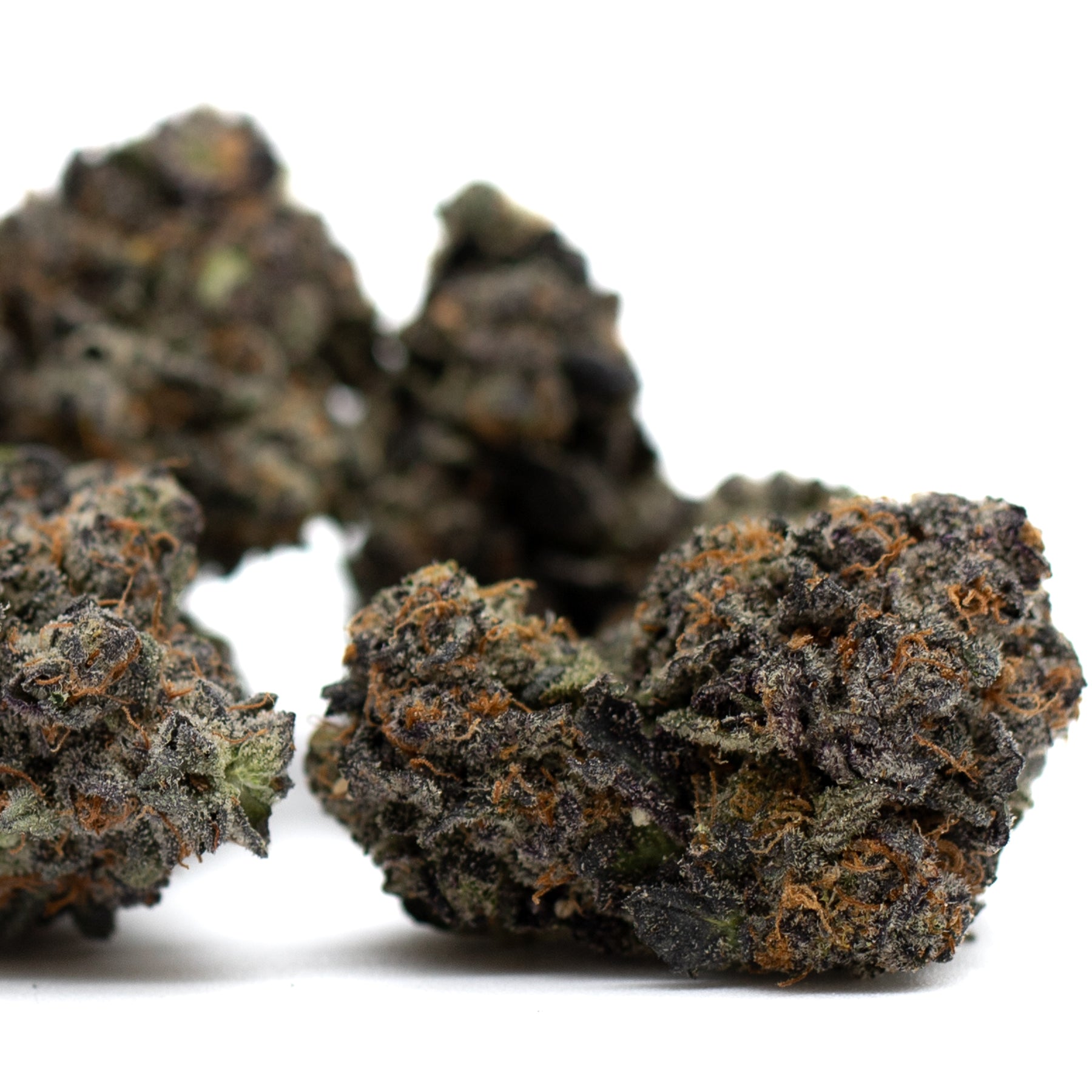 Dark dense cannabis buds with orange hairs and frosty appearance from Poppin Bottlez THCa Flower