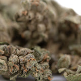 Potent Sour Apple THCa Flower Smalls with green leaves and white trichomes