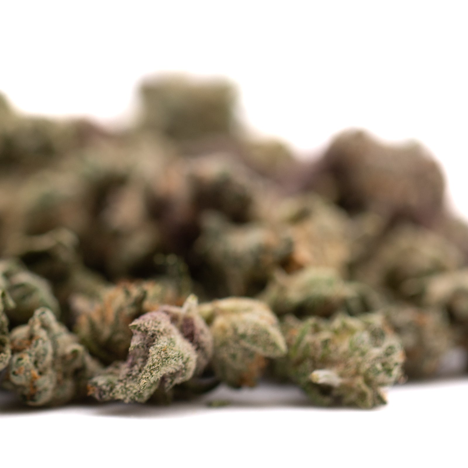 Pile of green and brown dried tea leaves representing Sour Candy Indoor THCa Flower Smalls