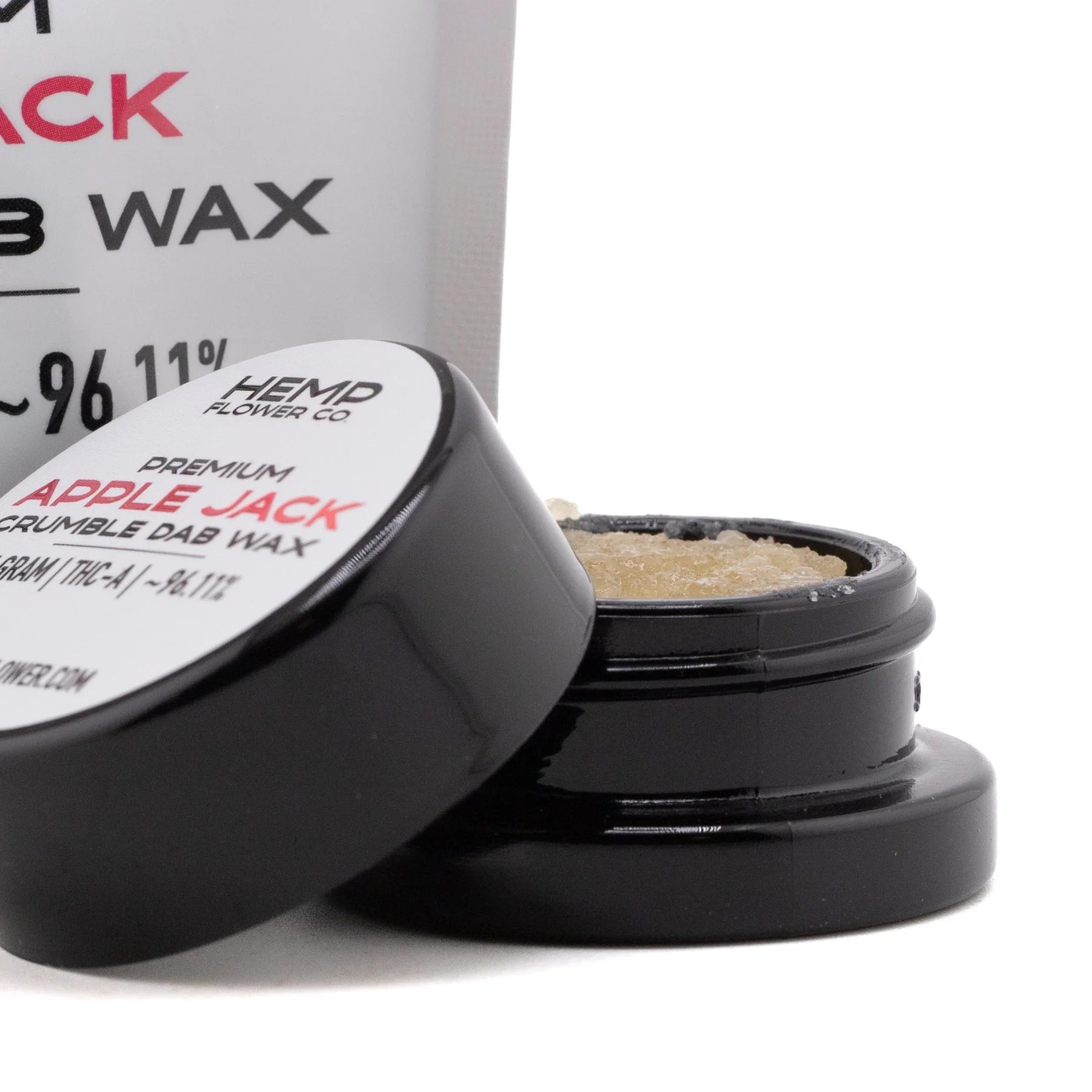 Black cylindrical container with glossy finish holding light amber apple jack thca crumble wax by hemp flower co