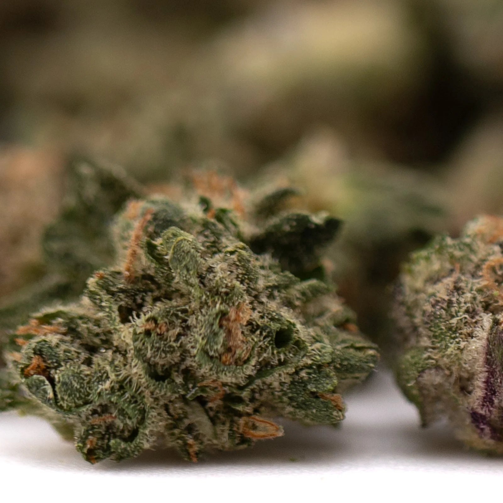 Sticky green and orange cannabis buds covered in trichomes from Astroboy Indoor THCa Flower Smalls